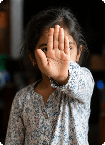 A child holding a palm up to the camera
