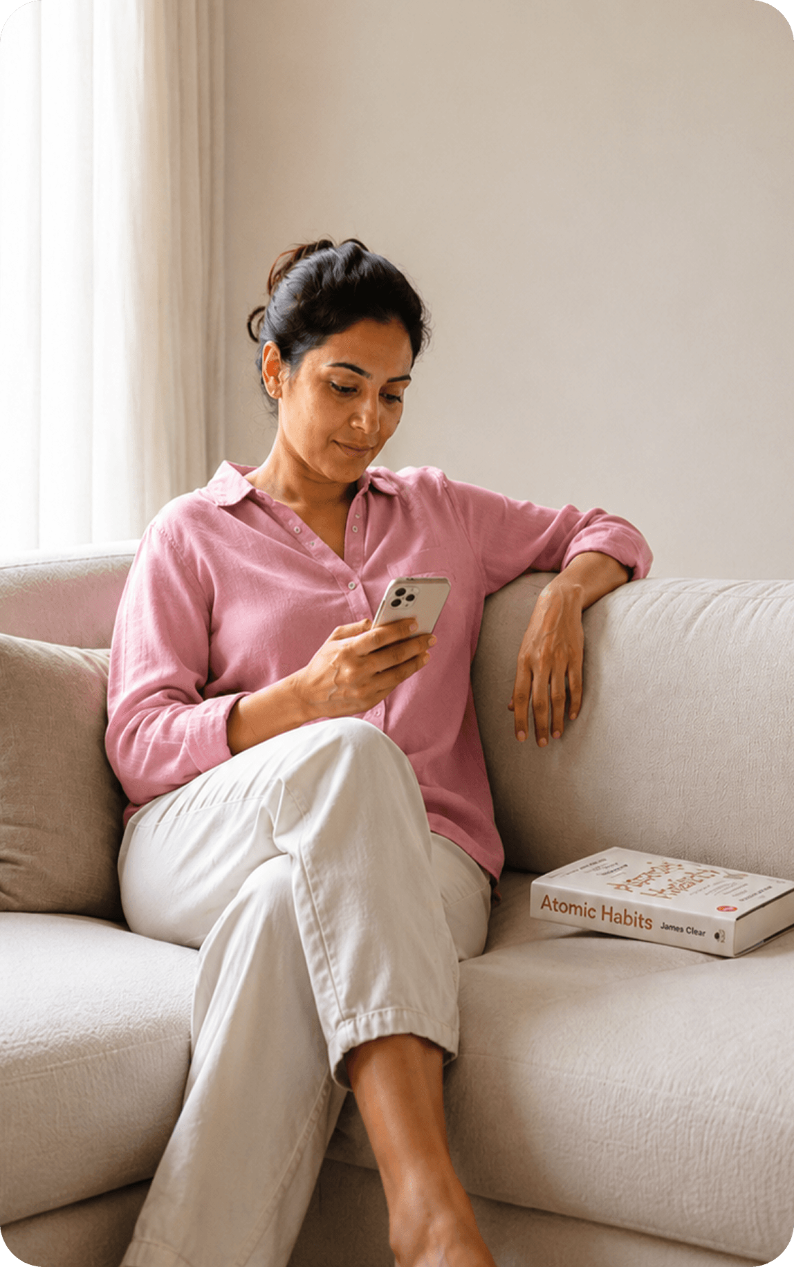 A mother sitting on a sofa, using her phone