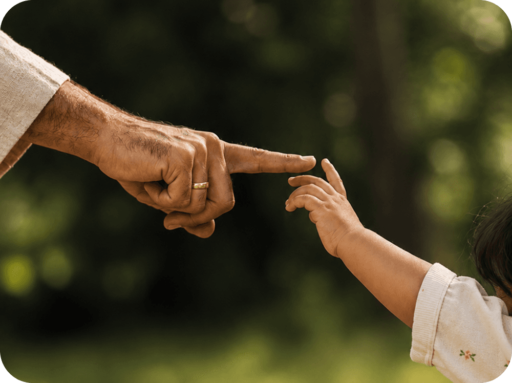 An adult's fingertip meeting a child's